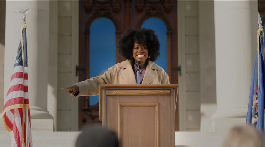 Woman speaks at protest, standing with conviction before a crowd